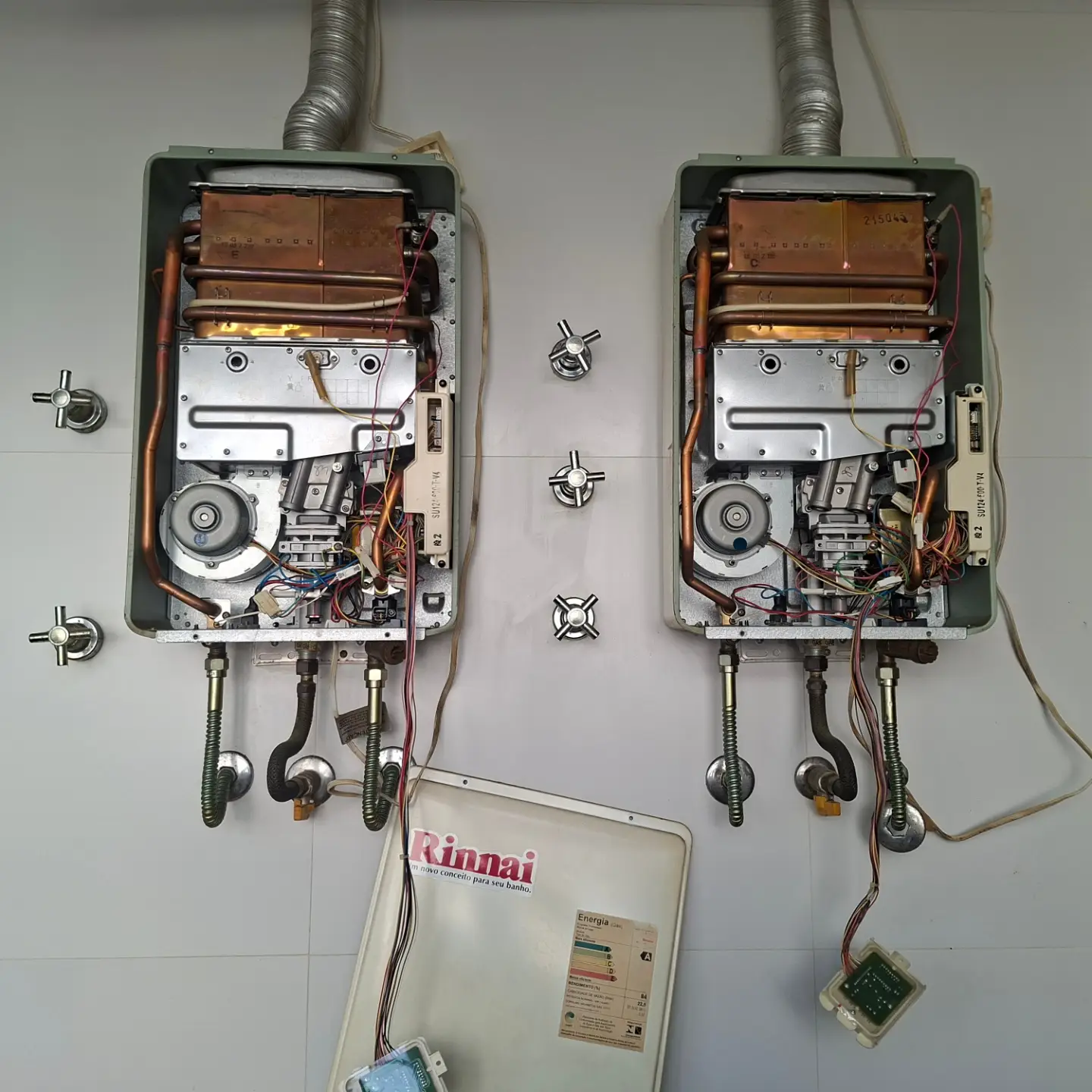 Dois aquecedores a gás em manutenção na bancada da Gás Fixe